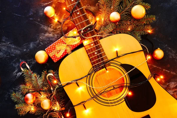 暗い背景にクリスマスライトや装飾とギター — ストック写真