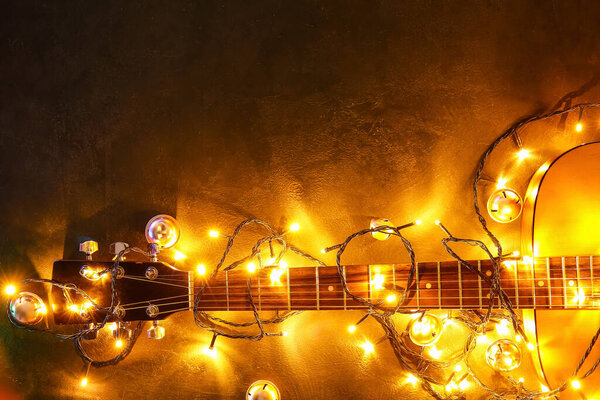 Guitar with Christmas lights and decor on grunge background