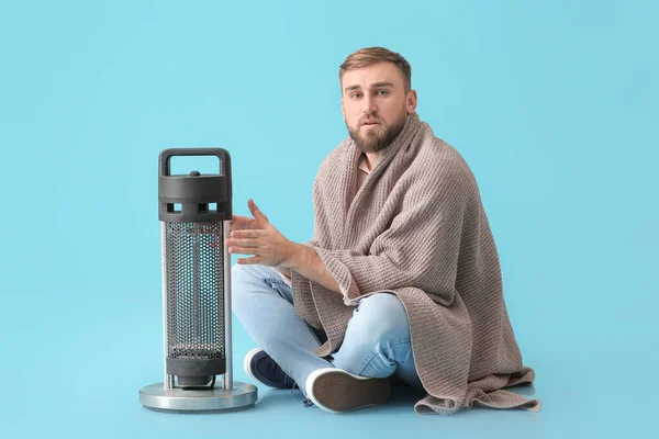 Hombre Joven Que Calienta Las Manos Cerca Del Calentador Eléctrico — Foto de Stock