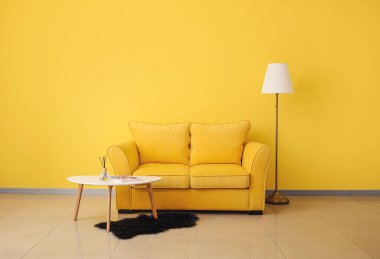 Renkli kanepesi, masası ve lambası olan şık bir oturma odası.