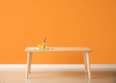 Odasında renk duvarı olan ahşap masa.