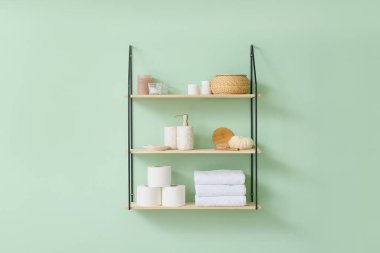 Renk duvarında banyo aksesuarları olan raflar