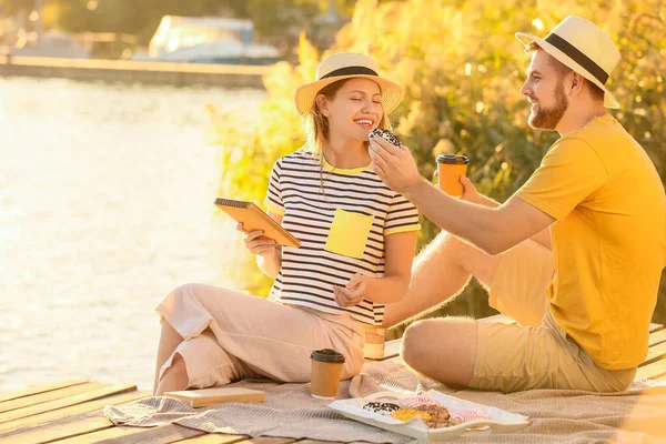 Pareja Joven Comiendo Rosquillas Dulces Tomando Café Cerca Del Río — Foto de Stock