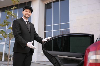 Lüks arabanın yanındaki yakışıklı şoförün portresi.