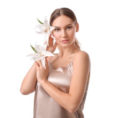 Beyaz arka planda taze zambakları olan güzel genç bir kadın.