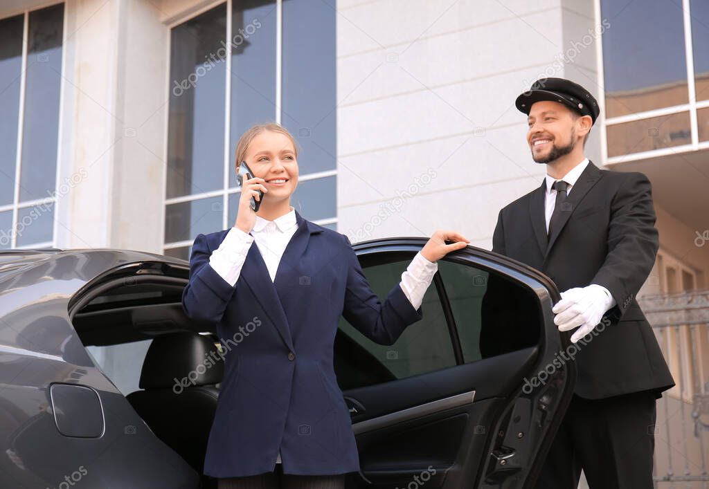 Young businesswoman getting out of luxury car