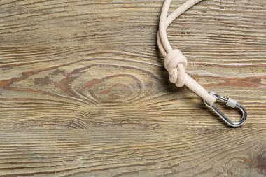 Ahşap arka planda ıstakoz tokalı ip.