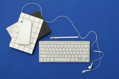 Renk arkaplanı üzerinde bilgisayar klavyesi, aygıtlar ve kırtasiye