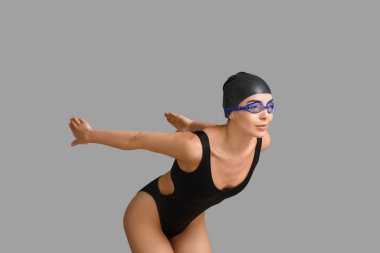 Gri arkaplanda kadın yüzücü