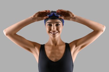 Gri arkaplanda kadın yüzücü