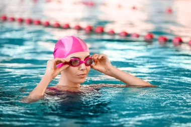 Havuzda yüzen genç bir kadın.