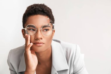 Hafif arka planda şık bir Afro-Amerikalı.