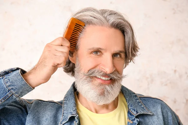 Reifer Mann Kämmt Haare Auf Hellem Hintergrund — Stockfoto