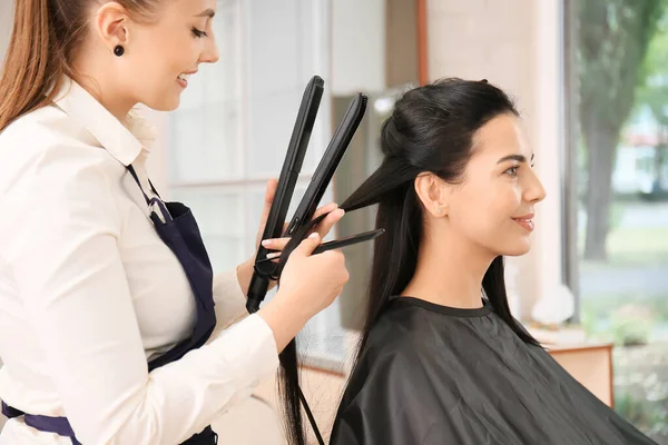 Женщина Парикмахер Выпрямляет Волосы Женщины Салоне — стоковое фото