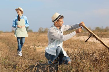 Çiftlikte salyangozlarla ilgilenen işçiler.