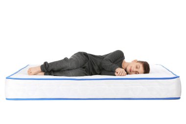 Beyaz arka planda yatağında uyuyan tatlı küçük çocuk.