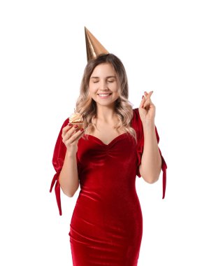 Doğum günü pastasıyla beyaz arka planda dilek tutan genç ve güzel bir kadın.