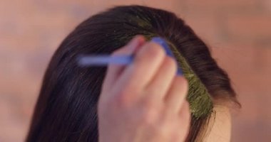 Evde kına saç boyası kullanan genç bir kadın, yakın plan.