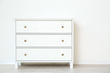 Beyaz duvarın yanındaki modern çekmeceler.