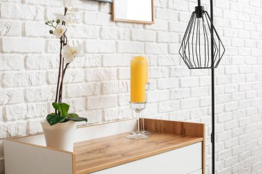 Odadaki tuğla duvarın yanındaki modern çekmeceler.