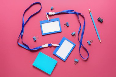 Renk arkaplanı üzerindeki boş rozetler ve kırtasiye malzemesi