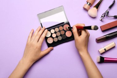 Göz falı kadın elleri ve renk arkaplanındaki kozmetik ürünleri