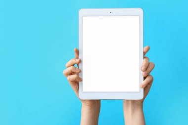 Renk arkaplanı üzerinde tablet bilgisayarı olan eller