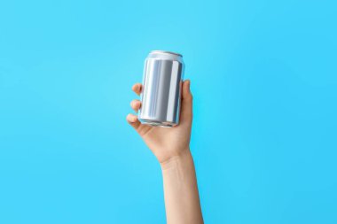Renk arkaplanında metal teneke olan el