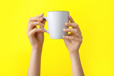 Renk arkaplan üzerinde fincan ile eller