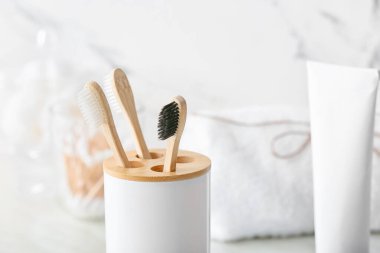 Banyodaki masada tahta diş fırçası ve diş macunu olan bir tutucu.