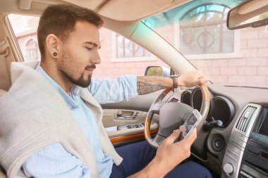 Modern arabasında cep telefonu olan yakışıklı bir adam.