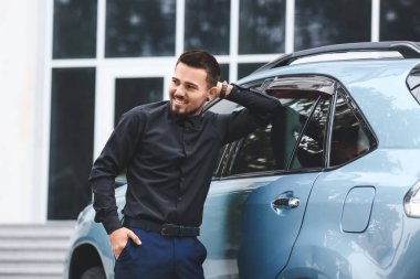 Modern arabanın yanındaki yakışıklı adam.