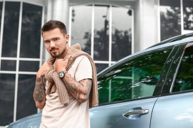 Modern arabanın yanındaki yakışıklı adam.