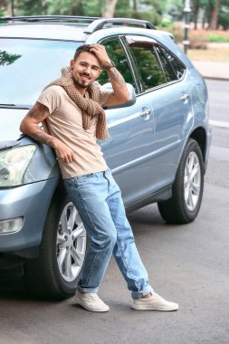 Modern arabanın yanındaki yakışıklı adam.