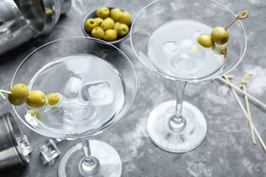 Arkaplanda zeytinli bir bardak lezzetli martini.