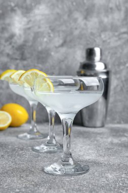 Bir bardak lezzetli martini ve arkaplanda limon.