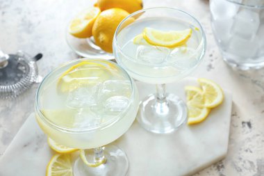 Hafif arka planda limonlu bir bardak lezzetli martini.