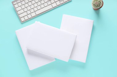 Renk arkaplanı üzerinde boş kitaplar ve bilgisayar klavyesi olan kompozisyon