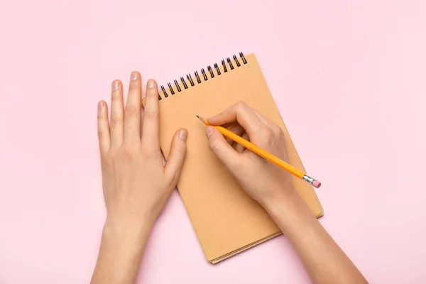 Manos Con Cuaderno Lápiz Sobre Fondo Color — Foto de Stock