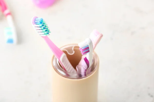 Holder with toothbrushes on table in bathroom