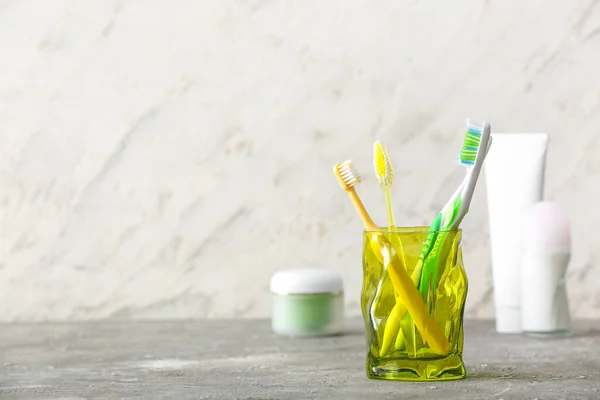 Holder with toothbrushes on table in bathroom