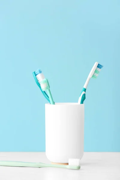 Holder with toothbrushes on table
