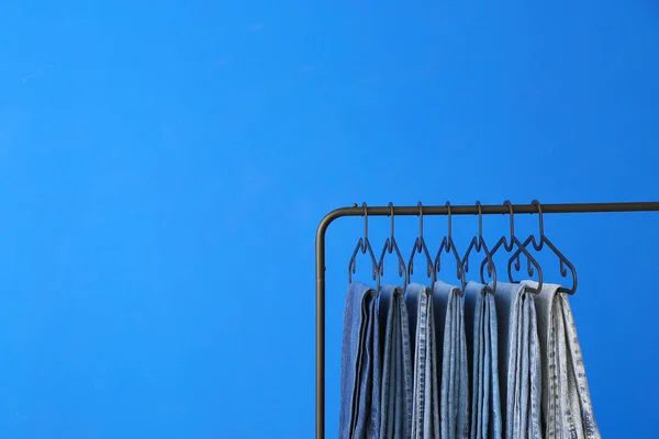 Stojak Ubrania Dżinsami Tle Koloru — Zdjęcie stockowe