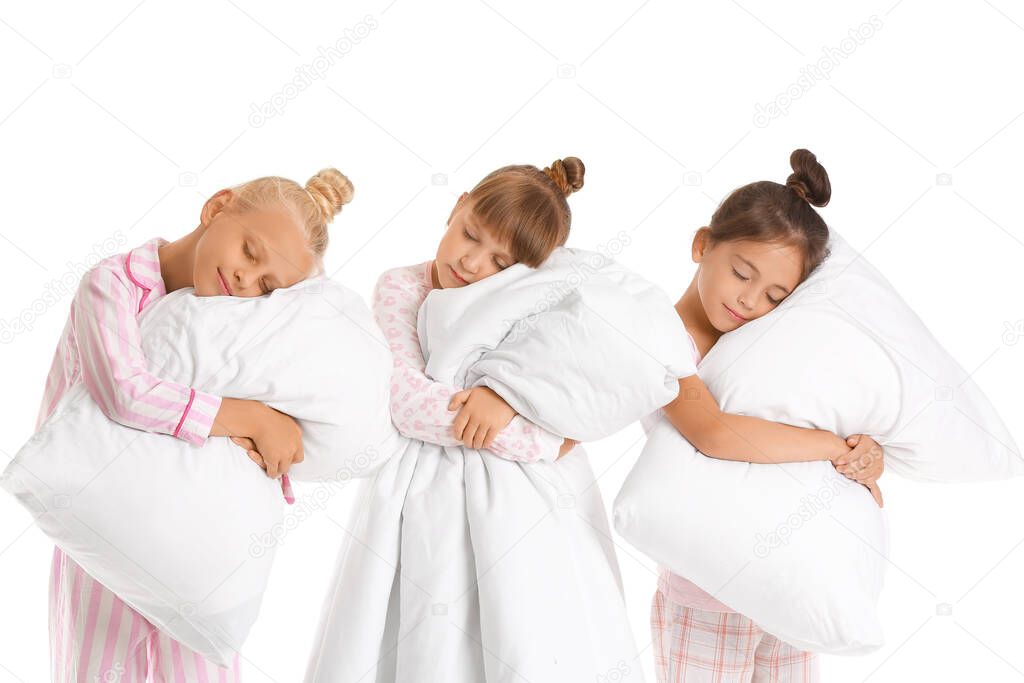 Sleeping little girls with pillows and blanket on white background