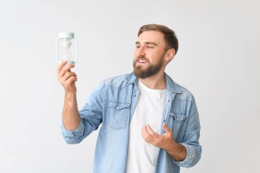 Arka planda kum saati olan genç bir adam.