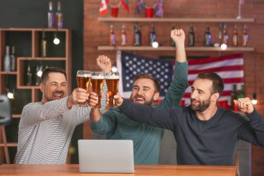 Bardaki spor bahislerini kazandıktan sonra mutlu adamlar.