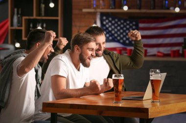 Bardaki spor bahislerini kazandıktan sonra mutlu adamlar.