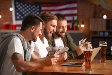 Bardaki spor bahislerini kazandıktan sonra mutlu adamlar.