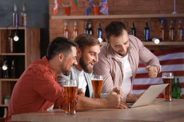 Bardaki spor bahislerini kazandıktan sonra mutlu adamlar.