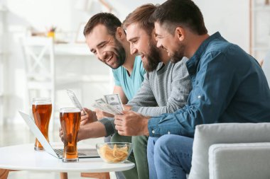 Evdeki spor bahislerini kazandıktan sonra mutlu adamlar.